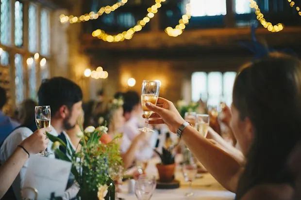 Guests raising glasses at a candle-lit reception